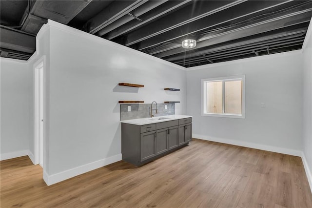 interior space with gray cabinetry, sink, and light hardwood / wood-style flooring