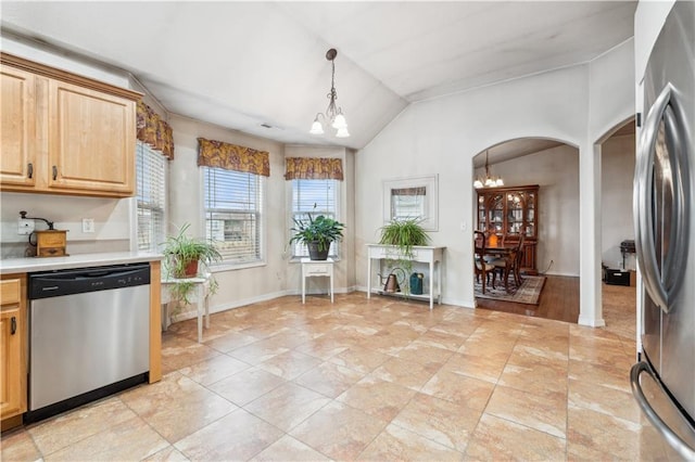 kitchen with a chandelier, light countertops, arched walkways, hanging light fixtures, and stainless steel appliances