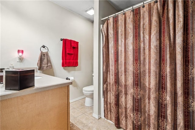 bathroom with tile patterned floors, toilet, vanity, and baseboards