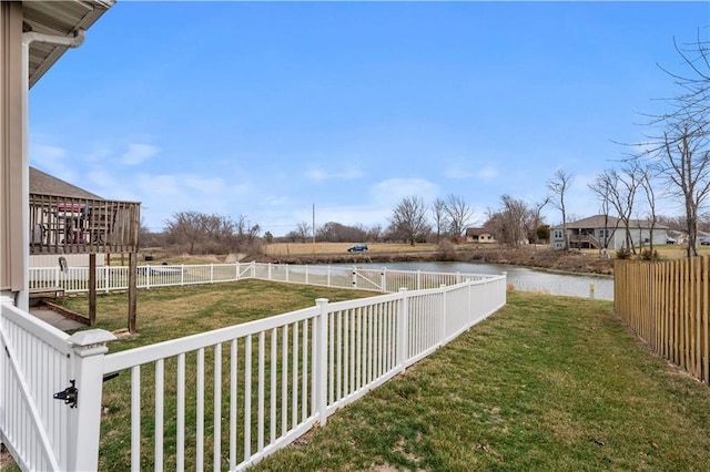 view of yard with a water view and a fenced backyard