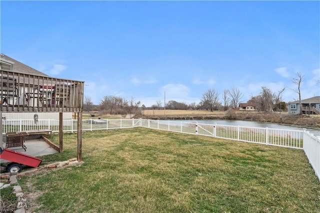 view of yard with a fenced backyard and a water view