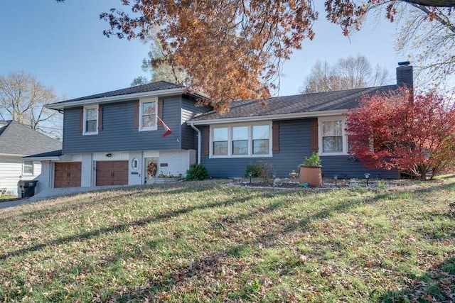 split level home featuring a front yard and a garage