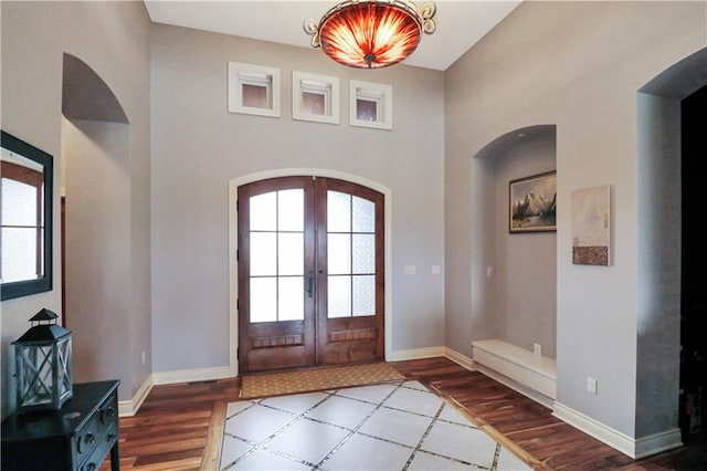 entrance foyer with hardwood / wood-style flooring, plenty of natural light, and french doors