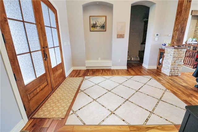 foyer with hardwood / wood-style floors, a wealth of natural light, and french doors