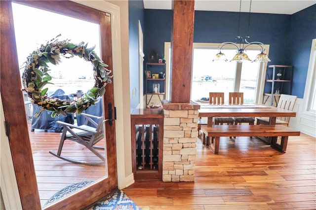 dining space featuring hardwood / wood-style flooring, a healthy amount of sunlight, and a chandelier