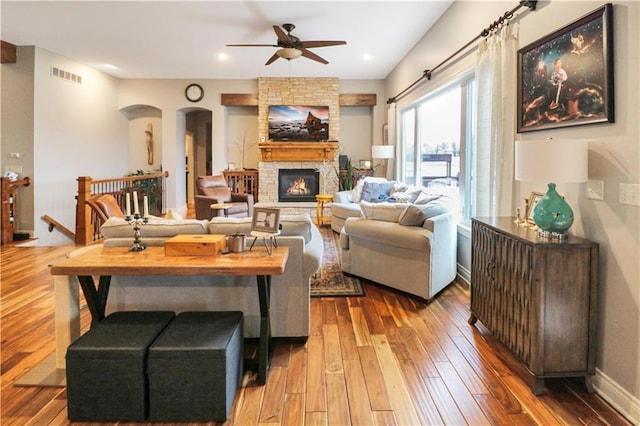 living room with hardwood / wood-style flooring, ceiling fan, and a fireplace