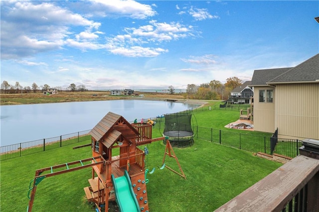 view of play area featuring a lawn, a water view, and a trampoline