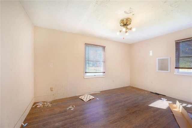 spare room featuring dark hardwood / wood-style floors and a healthy amount of sunlight