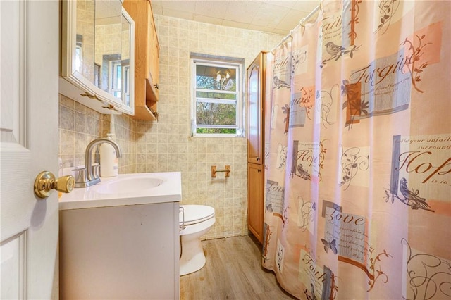 bathroom with hardwood / wood-style floors, vanity, toilet, and tile walls