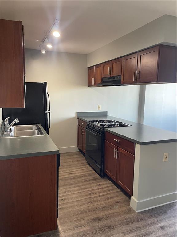 kitchen featuring dark wood-type flooring, sink, and black appliances