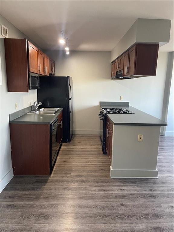 kitchen featuring ventilation hood, sink, dark hardwood / wood-style floors, and black appliances