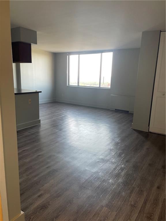 unfurnished room with dark wood-type flooring