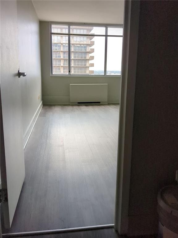 empty room with hardwood / wood-style flooring and radiator