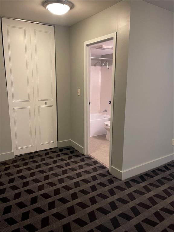 hallway with dark colored carpet