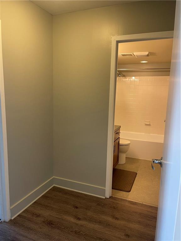 full bathroom featuring bathtub / shower combination, vanity, hardwood / wood-style flooring, and toilet