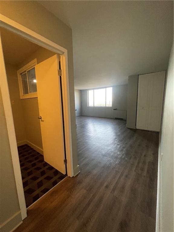 corridor with dark hardwood / wood-style flooring