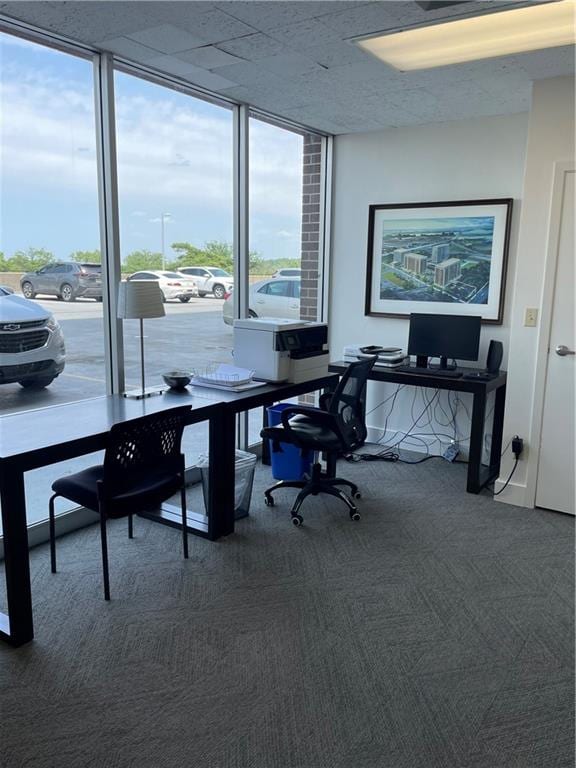 office space featuring dark colored carpet and floor to ceiling windows