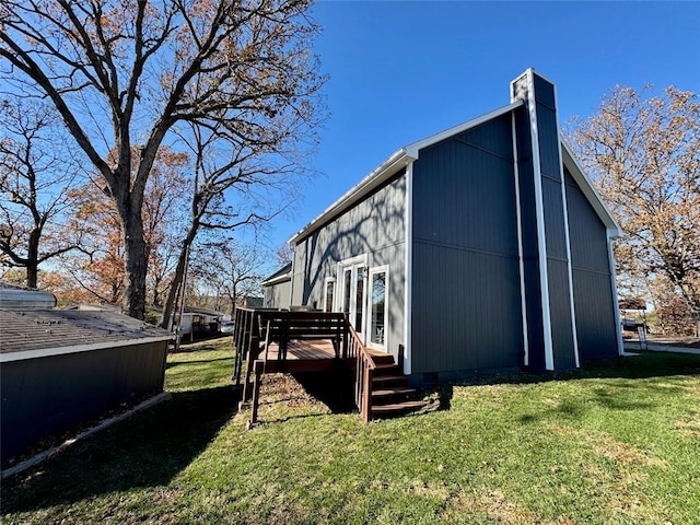 view of side of home featuring a yard and a wooden deck