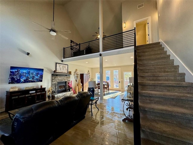 living room featuring a fireplace, high vaulted ceiling, and ceiling fan