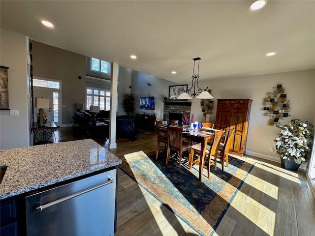 dining space with dark hardwood / wood-style floors and a stone fireplace