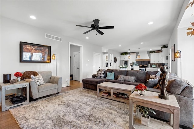 living room featuring ceiling fan and light hardwood / wood-style floors