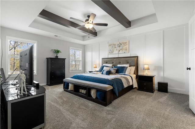 bedroom with a tray ceiling, ceiling fan, and light carpet