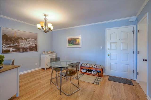 dining area featuring light hardwood / wood-style floors, crown molding, and a notable chandelier