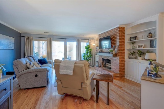 living room with built in shelves, light wood-type flooring, crown molding, and a brick fireplace