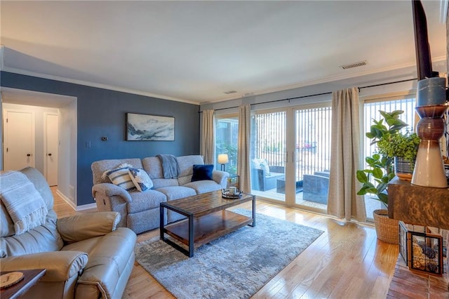 living room with light hardwood / wood-style flooring and crown molding