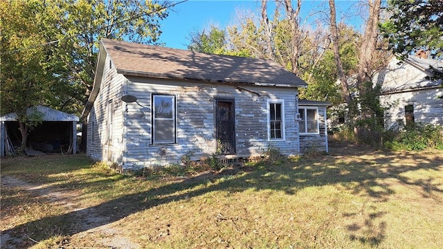 view of front facade with a front yard and an outbuilding