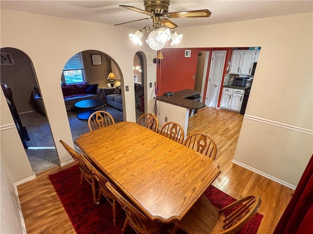 dining space featuring a textured ceiling, light hardwood / wood-style flooring, and ceiling fan