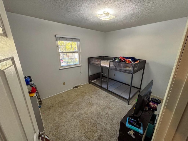 bedroom featuring light colored carpet and a textured ceiling