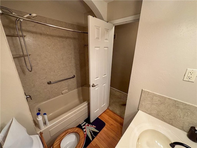 bathroom featuring tiled shower / bath combo and hardwood / wood-style flooring