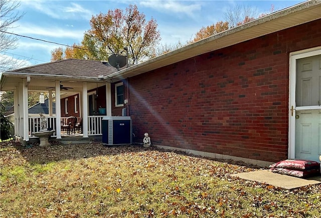 view of home's exterior featuring a lawn, central AC, ceiling fan, and a porch