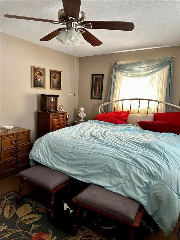 bedroom with a textured ceiling and ceiling fan