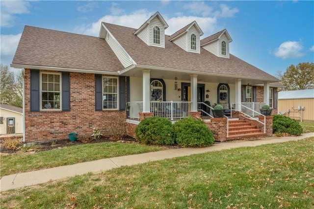 cape cod home featuring covered porch and a front lawn