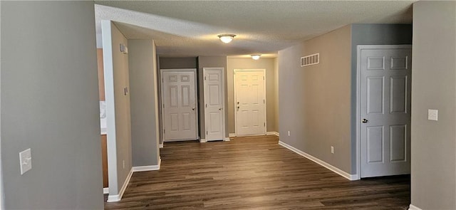 hallway featuring a textured ceiling and dark wood-type flooring