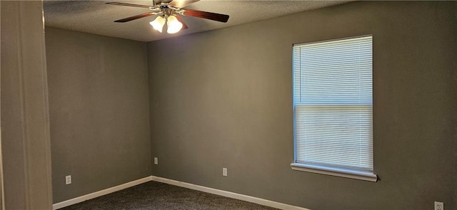 carpeted empty room featuring ceiling fan, plenty of natural light, and a textured ceiling