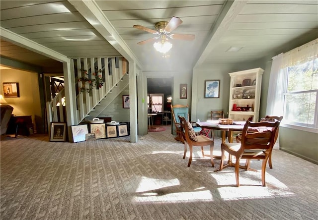 dining area with carpet, ceiling fan, and beamed ceiling