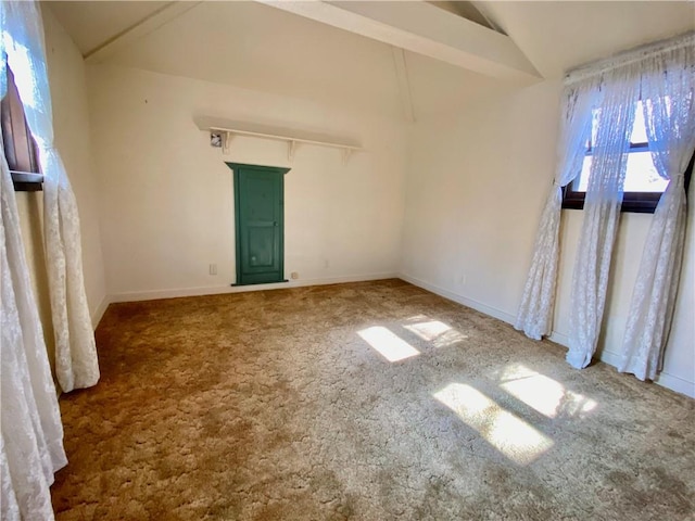 spare room featuring carpet and lofted ceiling with beams