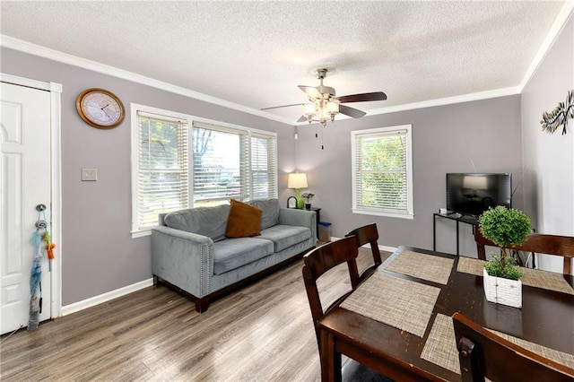 living room featuring a textured ceiling, hardwood / wood-style flooring, ceiling fan, and crown molding