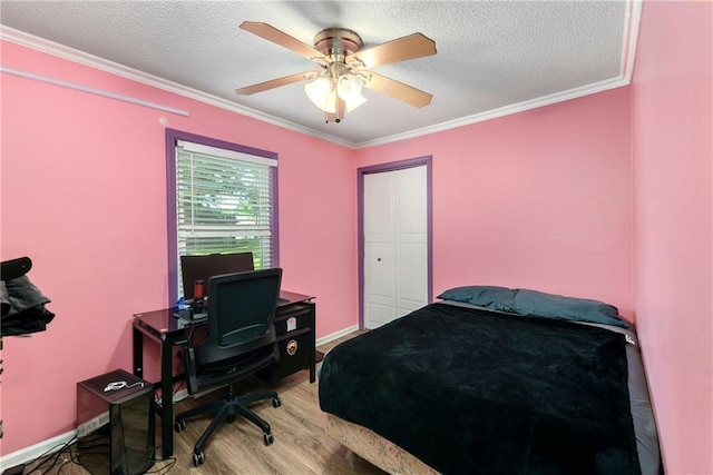 bedroom with ceiling fan, light hardwood / wood-style floors, ornamental molding, and a textured ceiling