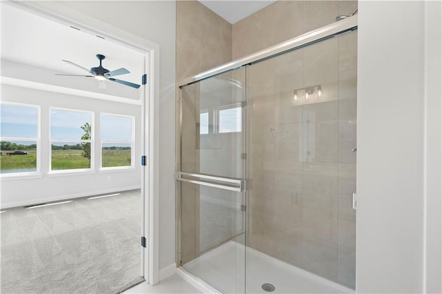 bathroom featuring ceiling fan and a shower with shower door