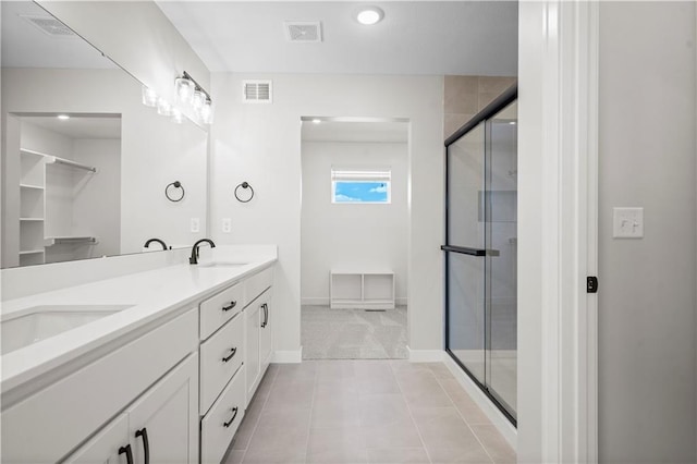 bathroom with tile patterned floors, vanity, and walk in shower