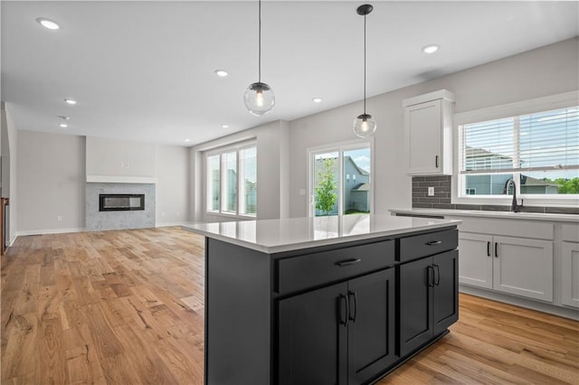 1933 SW Merryman Dr, Lees Summit, MO 64082 - kitchen with a sink, light wood-style floors, light countertops, a center island, and hanging light fixtures