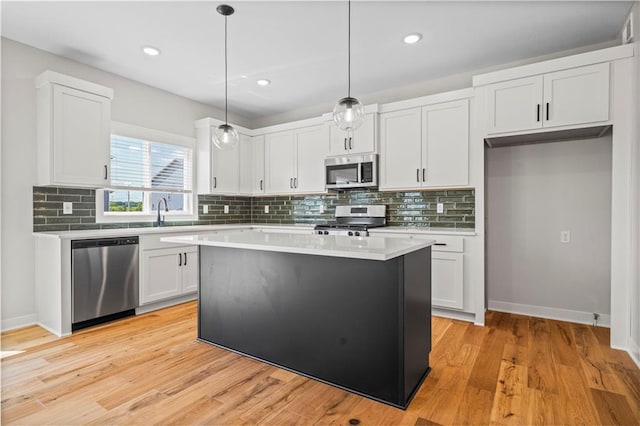 1933 SW Merryman Dr, Lees Summit, MO 64082 - kitchen featuring appliances with stainless steel finishes, light countertops, white cabinets, a kitchen island, and backsplash
