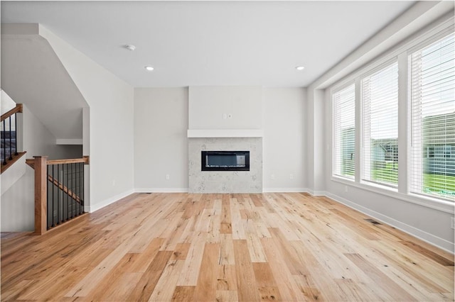 1933 SW Merryman Dr, Lees Summit, MO 64082 - unfurnished living room with wood finished floors, a glass covered fireplace, baseboards, and recessed lighting