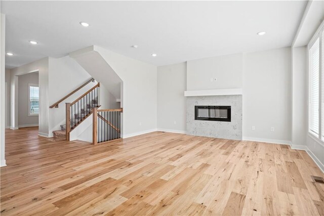 1933 SW Merryman Dr, Lees Summit, MO 64082 - unfurnished living room featuring light wood-style flooring, a fireplace, baseboards, and recessed lighting