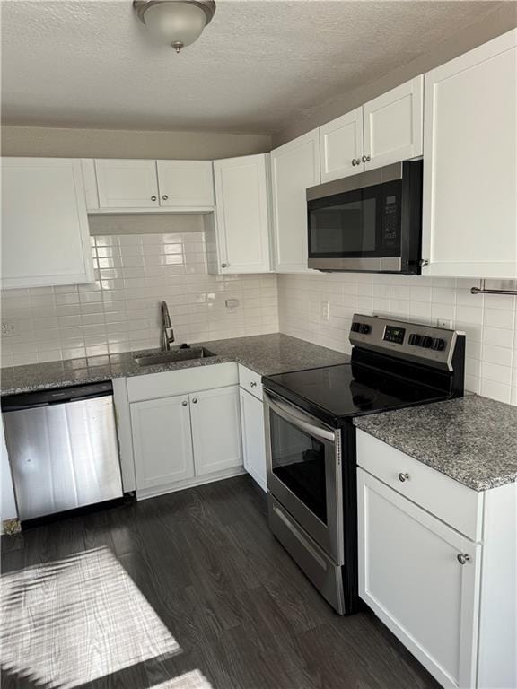 kitchen featuring dark hardwood / wood-style flooring, sink, white cabinetry, and stainless steel appliances