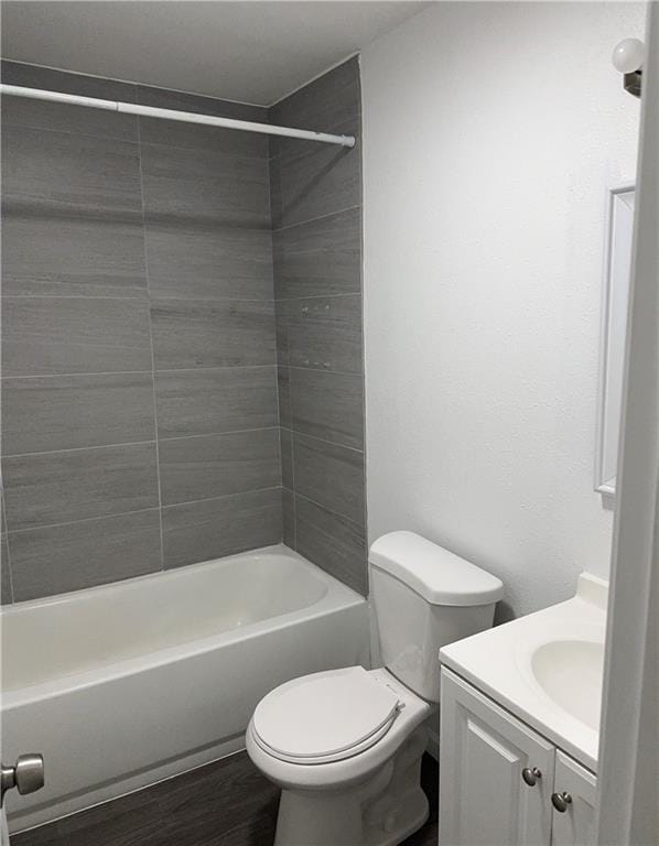 full bathroom featuring hardwood / wood-style flooring, vanity, toilet, and tiled shower / bath combo